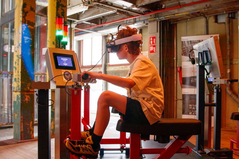 Korisnik s VR headsetom i kontrolnom pločom u industrijskom interijeru